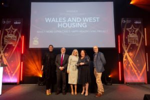 WWH Collecting award on stage at Welsh Housing Awards