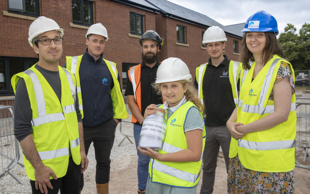 WWH staff with students from Northop school burying a time capsule on a construction site
