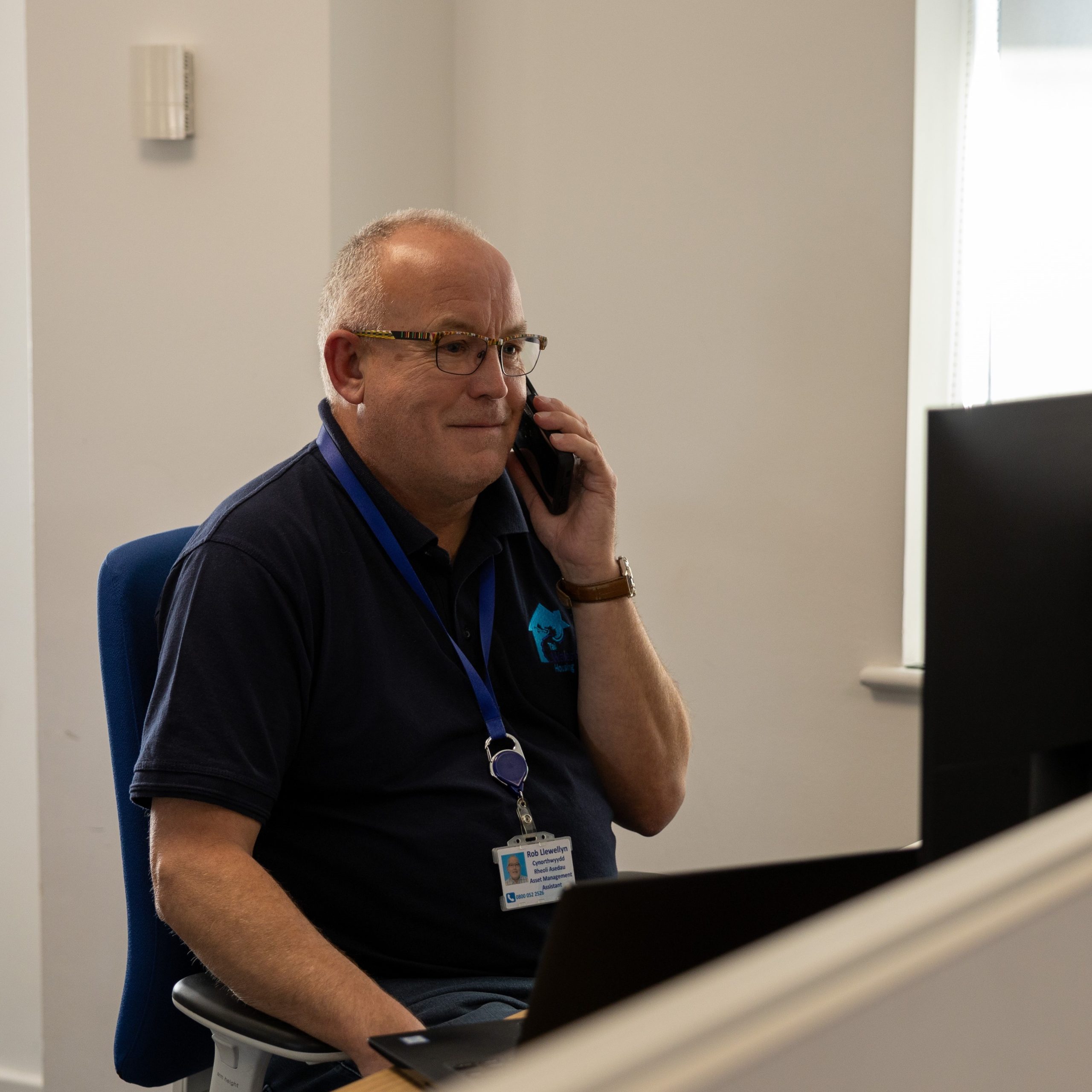 WWH staff member smiling whilst talking on a headset